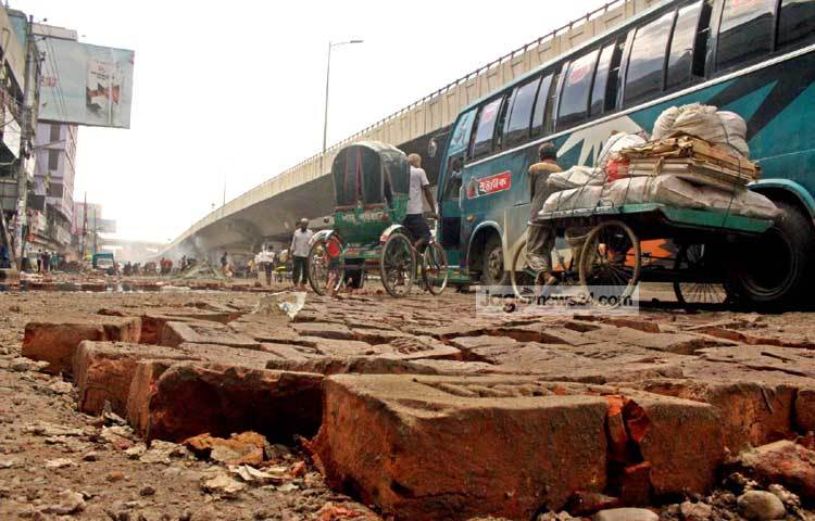 খানাখন্দে ভরা রাস্তা দিয়ে প্রতিদিন এভাবেই দূরপাল্লার বাস এবং রিক্সা চলছে। ছবি : বিপ্লব দিক্ষিৎ।