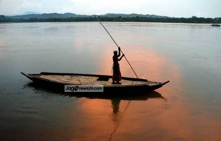 সোমেশ্বরী নদী বুকে মাঝি নৌকা ভাসিয়েছেন। নদীর জলে শেষ বিকেলে আলো আঁধারির খেলা। ছবি : মাহবুব আলম।