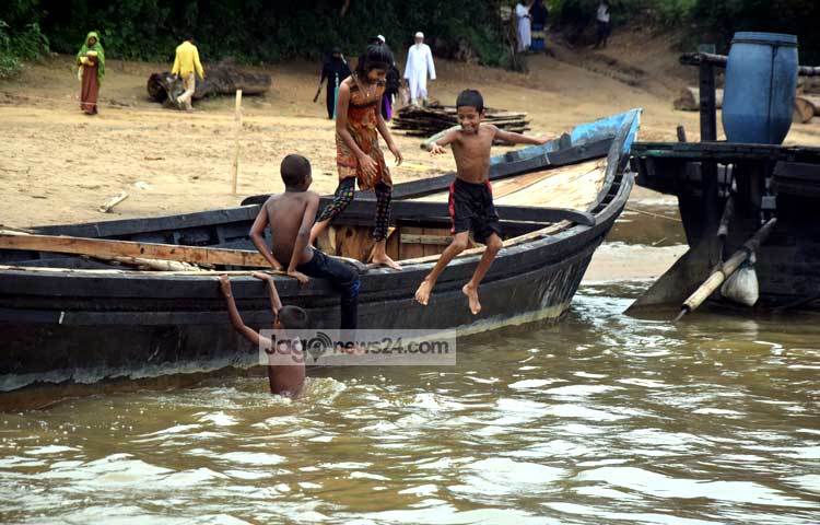 শিশুরা সোমেশ্বরী নদীর তীরে বসে খেলা করছে। এ নদী যেন তাদের নিত্যদিনের খেলার সাথী। ছবি : মাহবুব আলম।