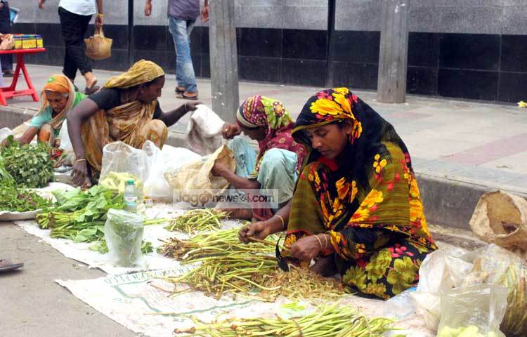 শাক কাটাকুটির কাজে ব্যস্ত সবজি ব্যবসায়ীরা। রান্নার উপযোগী করে এসব শাক বিক্রি করা হলেও দাম হাতের নাগালে। ছবি : বিপ্লব দিক্ষিৎ।