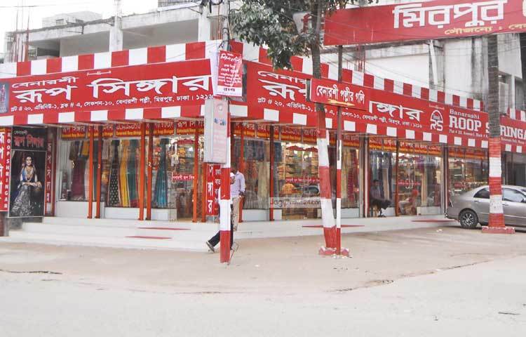 মিরপুরের বেনারসি পল্লীর শাড়ির দোকানের কর্মীরা বসে বসে অলস সময় কাটাচ্ছেন। ছবি : বিপ্লব দিক্ষিৎ।