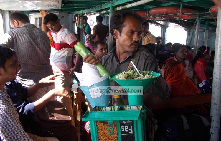 লঞ্চের মধ্যে হকাররা ঝাল মুড়ি বিক্রি করছেন। অন্যদিকে যাত্রীরা লঞ্চের জানালা দিয়ে নদীর সৌন্দর্য উপভোগ করছেন। ছবি : রবিউল ইসলাম পলাশ।