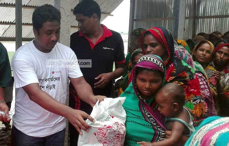 সারিবদ্ধভাবে দাঁড়িয়ে ত্রাণ নিচ্ছেন নীলফামারীর বন্যার্ত মানুষ।