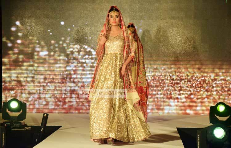 ধীর পায়ে ফ্যাশন শোতে দর্শকদের সম্মুখে এগিয়ে আসছেন দুই মডেল। ছবি : মাহবুব আলম।