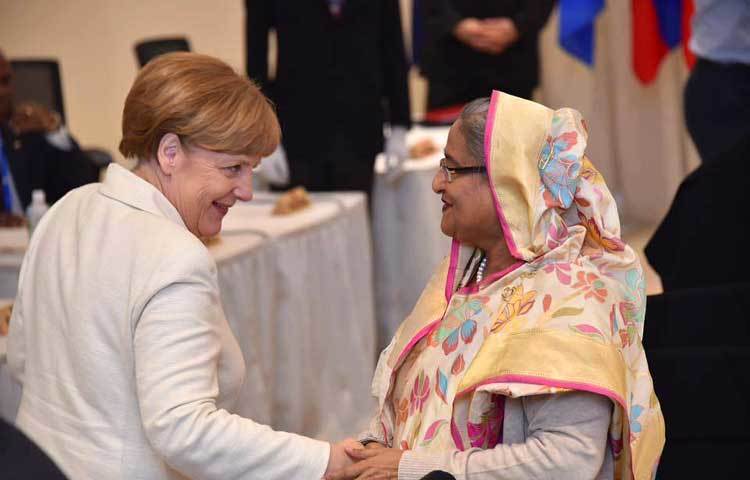 জার্মান চ্যান্সেলর অ্যাঙ্গেলা মেরকেলের সঙ্গে প্রধমানমন্ত্রী শুভেচ্ছা বিনিময় করছেন প্রধানমন্ত্রী শেখ হাসিনা।