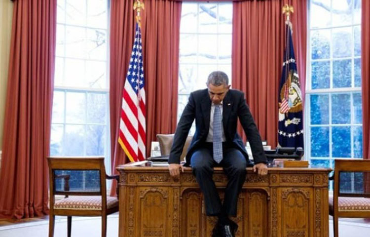 কখনো কখনো কাজের মাঝে এভাবে টেবিলের উপরেও চড়ে বসেন ওবামা। যেন সাধারণ একজন মানুষ।