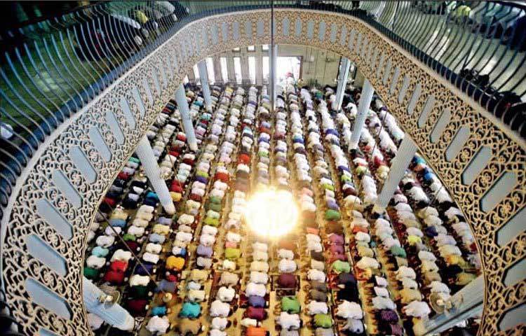 মসজিদের ভেতরে নামাজ পড়ার দৃশ্য। আধুনিক স্থাপত্যে অল্প অলংকরণই এ মসজিদটির লক্ষণীয় বৈশিষ্ট্য, যা দেখতে অনেকটা পবিত্র কাবা শরিফের মতো।&nbsp;