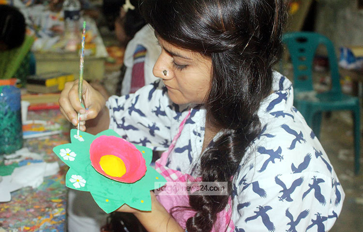 কাগজের ফুলে তুলির আচড়ে তৈরি করা হচ্ছে মঙ্গল শোভাযাত্রার অনুষঙ্গ। ছবি : বিপ্লব দিক্ষিৎ