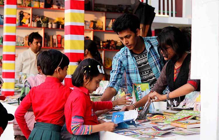 নতুন বইয়ের মাঝে হারিয়ে গেছে দুই শিশু। ছবি : মাহবুব আলম