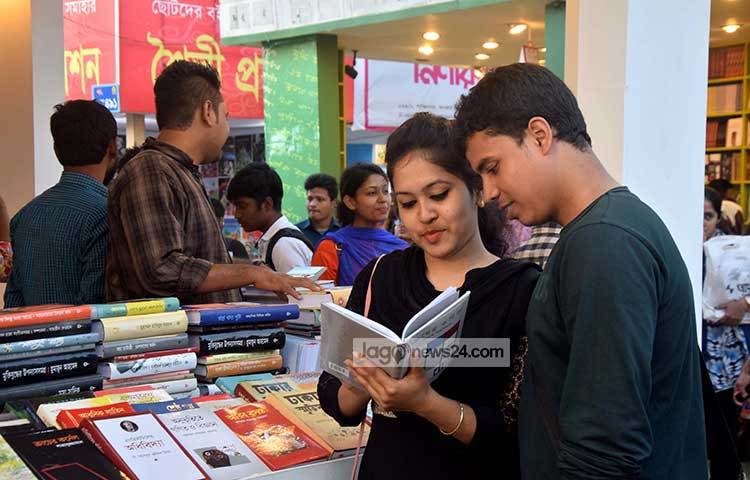 প্রিয় লেখকের প্রিয় বই খুঁজে পেয়েছেন তারা। তাই মেলার স্টলের সামনে বসেই কিছুটা পড়ে নিচ্ছেন। ছবি : মাহবুব আলম