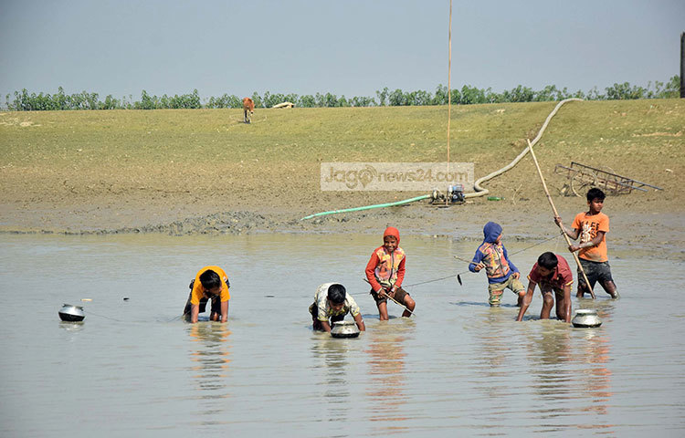মাছ ধরে পাতিলে রাখছে শিশুরা। পাতিল যেনো দূরে না যেতে পারে, সে জন্য পাতিলের সঙ্গে সবার গলায় রশি বেঁধে নেওয়া হয়েছে। ছবি : মাহবুব আলম