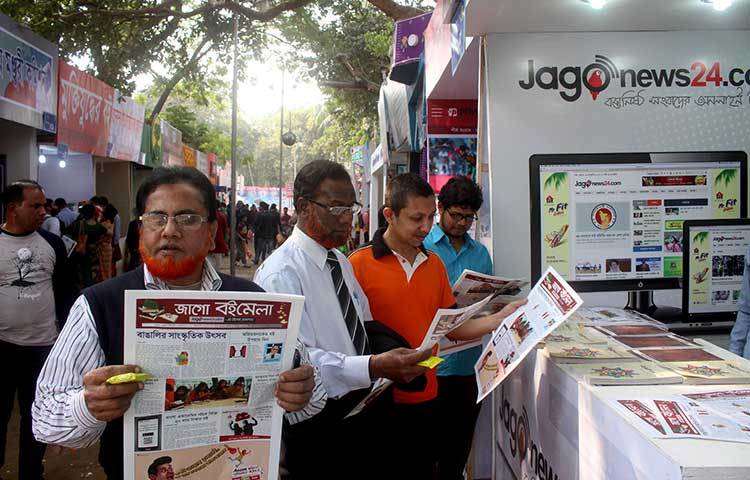 জাগো নিউজের স্টলের সামনে পাঠকের হাতে জাগো বইমেলার বুলেটিন। ছবি : বিপ্লব দিক্ষিৎ