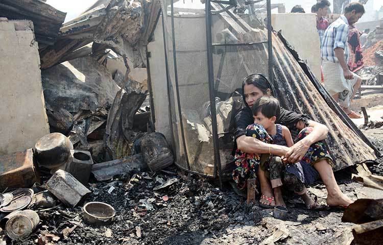 আগুনে সব হারিয়ে নিস্ব হয়েছে এই পরিবারটি। চারদিকে পোড়া গন্ধে বাতাস ভারি হয়ে আসছে। ছবি : বিপ্লব দিক্ষিৎ