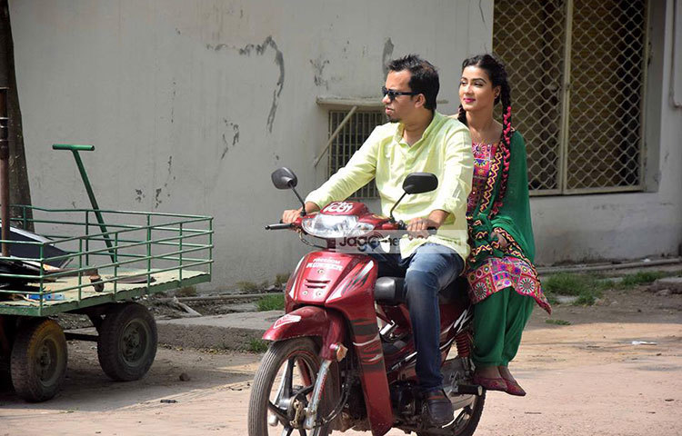 স্কুটিতে স্বামীর সঙ্গে হাস্যোজ্জ্বল মাহি। ছবি : মাহবুব আলম