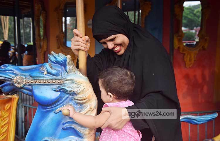 শিশু পার্কে এসে সন্তানকে নিয়ে আনন্দ করছেন মা। একজন মা তার সন্তানের আনন্দের জন্য সবকিছু করতে পারেন। ছবি : মাহবুব আলম