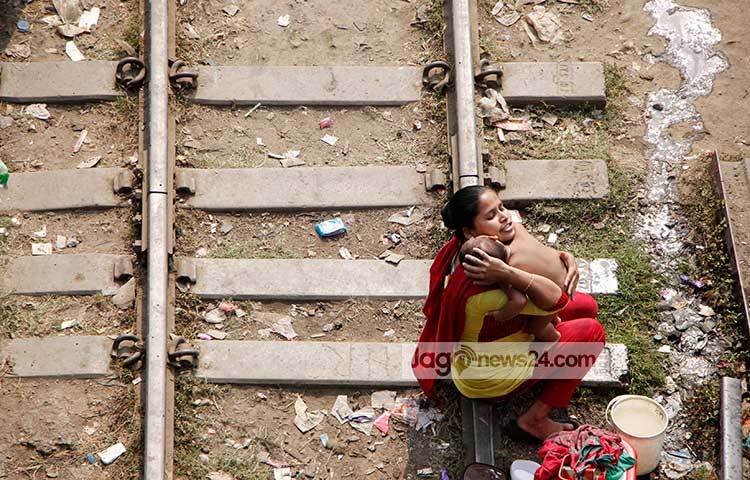 গোসল করানো শেষে সন্তানকে নিয়ে পরম মমতায় আদর করছেন মা। ছবি : মাহবুব আলম