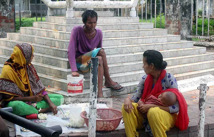সন্তান কোলে নিয়ে একজন ছিন্নমূল মা বসে আছেন। ঢাকা বিশ্ববিদ্যালয় এলাকা থেকে এ ছবি তুলেছেন আলোকচিত্রী দিপ্লব দিক্ষিৎ। ছবি : দিপ্লব দিক্ষিৎ