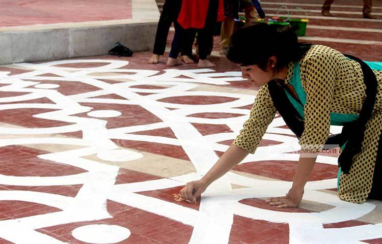 মনের মাধুরী মিশিয়ে চলছে শহীদ মিনারের বেধিতে আলপনা অঙ্কন। ছবি : বিপ্লব দিক্ষিৎ