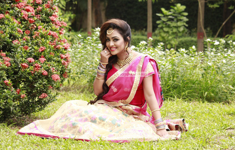 ফুলের হাসি আর সবুজ ঘাসের মাঝে মিশে গেছেন তানহা। ছবি : মাহবুব আলম