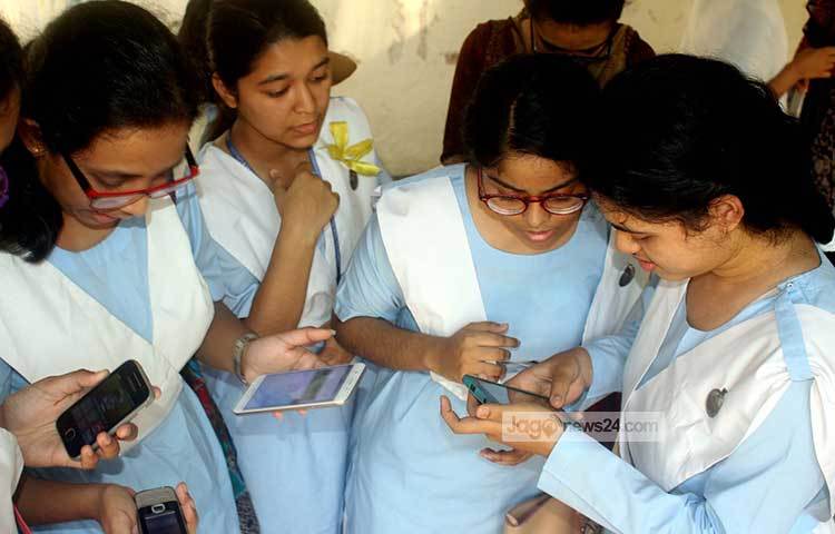 মোবাইলে ফলাফল জেনে নিতে ব্যস্ত শিক্ষার্থীরা। দীর্ঘ প্রতীক্ষার পরে তাদের এই ফলাফল। ছবি : বিপ্লব দিক্ষিৎ