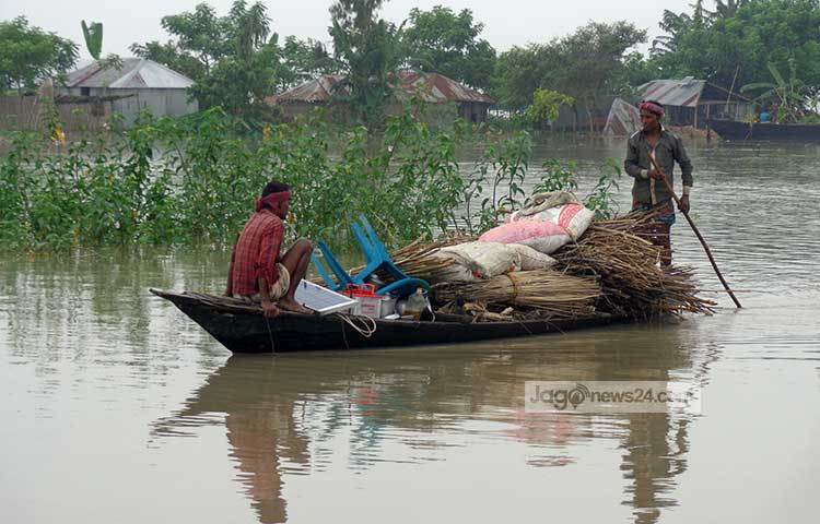 পানিবন্দি মানুষ নৌকায় করে তাদের নিত্যপ্রয়োজনীয় জিনিসপত্র শুকনো স্থানে নিয়ে যাচ্ছে। ছবি : রওশন আলম পাপুল