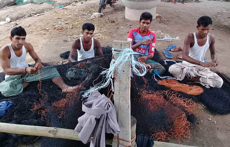 চার কিশোর জেলে নতুন জাল মাছ ধরার উপযোগী করার কাজ করছে। ছবি : কাজী সাঈদ।