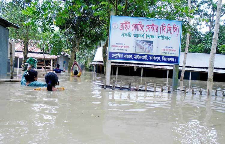 নিরাপদ আশ্রয়ের সন্ধানে ছুটছে মানুষ। হঠাৎ বন্যা এ অঞ্চলের মানুষের জীবনের গতিকে থমকে দিয়েছে। ছবি : ইউসুফ দেওয়ান রাজু