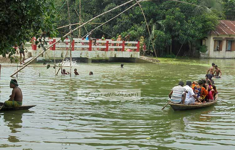 রাস্তা-ঘাট ডুবে যাওয়ায় সিরাজগঞ্জের মানুষ নৌকায় করে যাতায়াত করছে। ছবি : ইউসুফ দেওয়ান রাজু