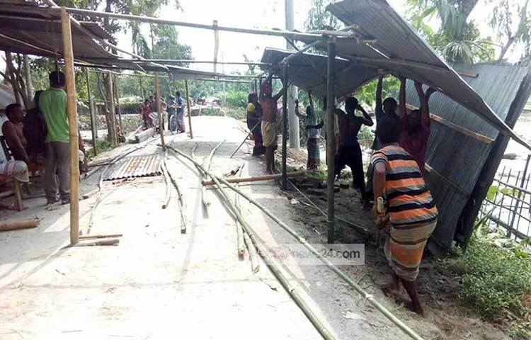 হাতীবান্ধার গড্ডিমারী ইউনিয়নের শাহ্ আলম (৩৫) এর বাড়ি ভিটেসহ নদীতে বিলীন হলে থাকার জায়গা না পেয়ে পাকারাস্তার উপর টিনের চালা পেতে থাকার চেষ্টা করছেন। ছবি : রবিউল হাসান