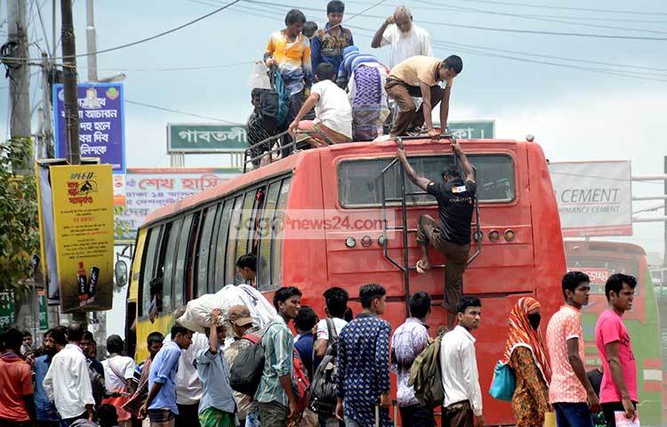 জীবনের ঝুঁকি নিয়ে বাসের ছাদে উঠছে ঘরমুখো মানুষ। শত কষ্টের মাঝে মনে তাদের আনন্দের কমতি নেই। ছবি : বিপ্লব দিক্ষিৎ