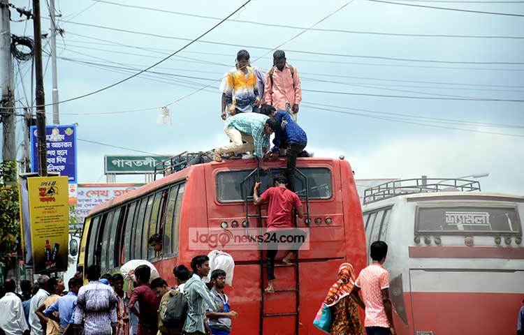 বাসে ওঠার যুদ্ধ। যেভাবেই হোক বাসের ছাদে করে হলেও বাড়ি যেতে হবে। নাড়ির টানে বাড়ি ফেরার কাছে সব বাধাই তুচ্ছ। ছবি : বিপ্লব দিক্ষিৎ