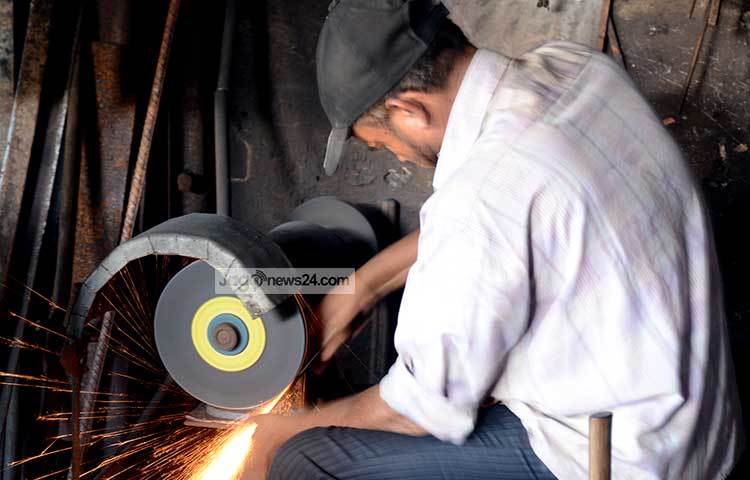 ছুরি-চাপাতিতে ধার দিচ্ছেন একজন দোকানী। এই কাজে কয়েকদিন ধরে খুব ব্যস্ত তিনি। ছবি : বিপ্লব দিক্ষিৎ