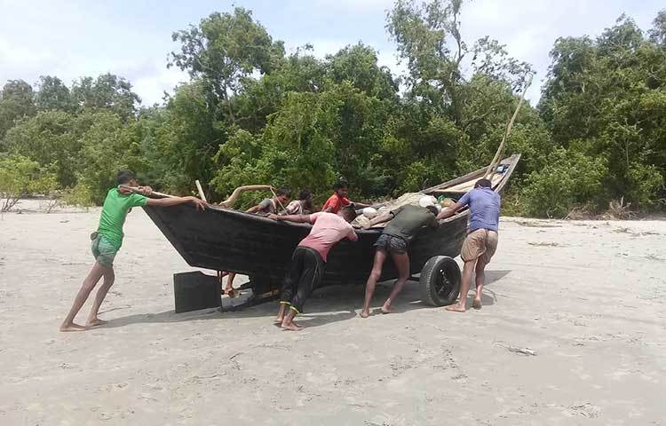 জাল ভর্তি নৌকা ট্রলার নিরাপদ স্থান সংরক্ষিত বনাঞ্চলে নিয়ে যাচ্ছেন জেলেরা। ছবি : কাজী সাঈদ
