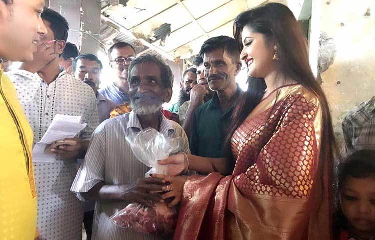 কোরবানির মাংস বিতরণকালে হাস্যোজ্জ্বল পরীমনি।