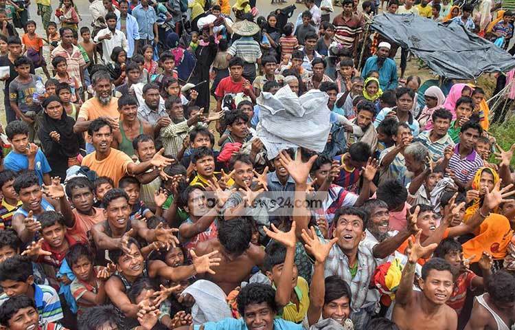 হাজারো অসহায় রোহিঙ্গার মাঝে পোশাক ছুড়ে দেয়া হচ্ছে। ছবি : মাহবুব আলম