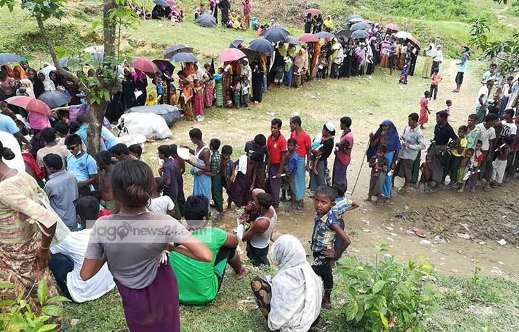 ত্রাণ নিতে লাইন ধরে দাঁড়িয়েছে স্বদেশ থেকে বিতাড়িত রোহিঙ্গারা। ছবি : মাহবুব আলম