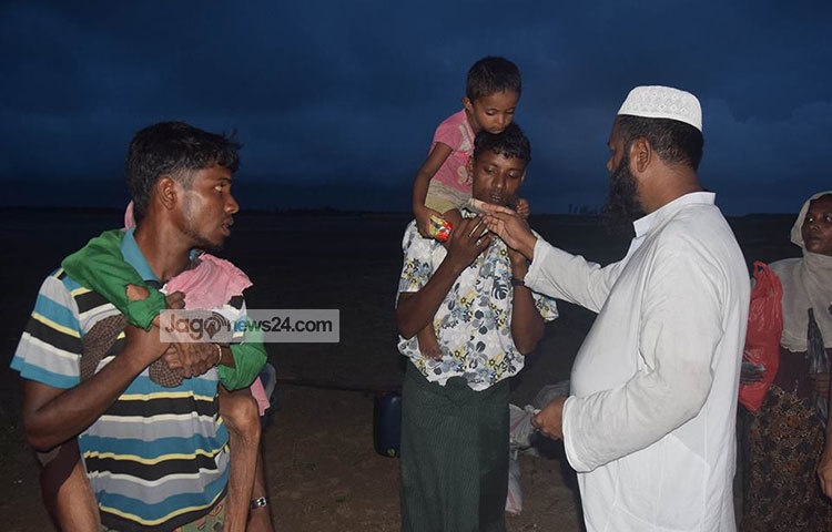 রোহিঙ্গাদের প্রতি মানবিক সাহায্যের হাত। এক রোহিঙ্গার হাতে নগদ টাকা তুলে দেওয়া হচ্ছে। ছবি : মাহবুব আলম