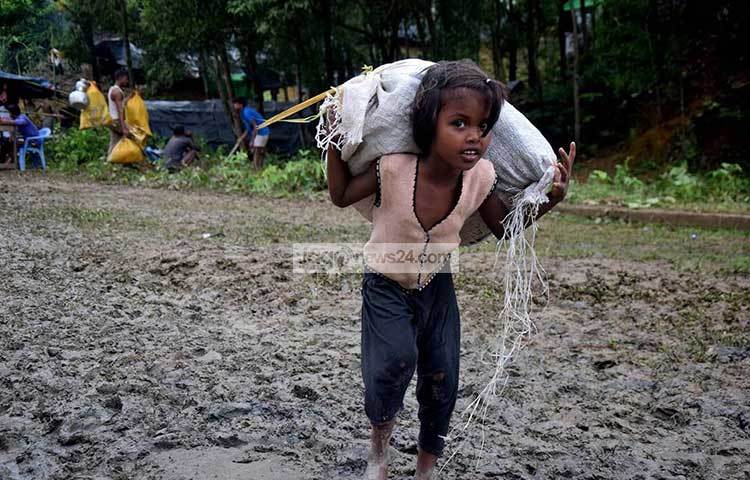 পিঠে বস্তা নয়, যেন জীবনের ভার বহন করে নিয়ে যাচ্ছে এই রোহিঙ্গা শিশুটি। ছবি : মাহবুব আলম