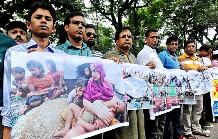রোহিঙ্গাদের অসহায় বিপন্ন দৃশ্যের ব্যনার নিয়ে প্রতিবাদী মানুষগুলো মানববন্ধন করছে। ছবি : বিপ্লব দিক্ষিৎ
