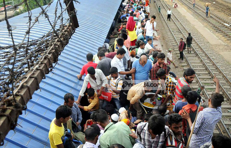 বেড়েছে ভিড়, ট্রেনের ছাদে ঝুঁকি নিয়ে নাড়ির টানে বাড়ি ছুটছে মানুষ। ছবি : বিপ্লব দিক্ষিৎ