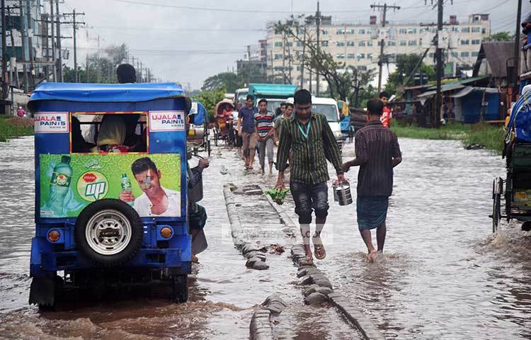 রাস্তার ওপর দিয়ে নদীর জোয়ারের মত স্রোত বইছে। কর্মজীবী মানুষের ভোগান্তির শেষ নেই। ছবি : মাহবুব আলম