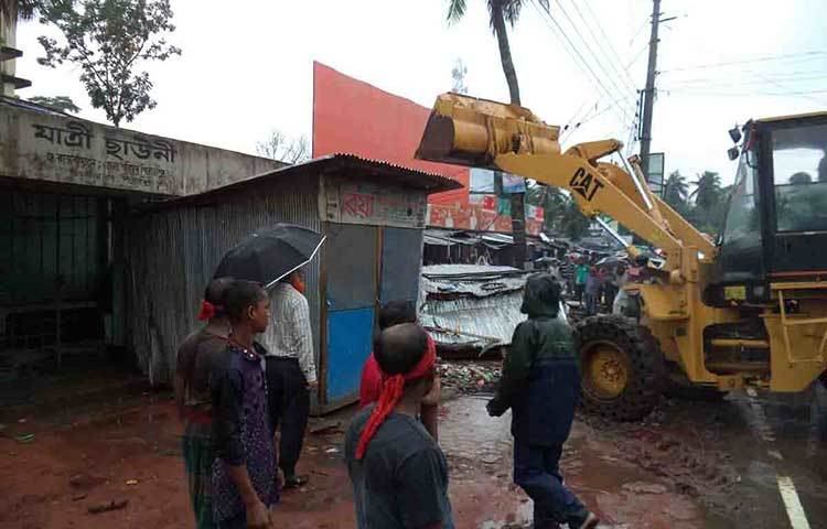 এক শ্রেণির চাঁদাবাজ ও হকার দীর্ঘ দিন ধরে পিরোজপুরের এ সড়কের পাশের ফুটপাত দখল করে এসব স্থাপনা ভাড়া ও পথচারীদের যাতায়াতে প্রতিবন্ধকতা তৈরি করে আসছিল। ছবি : হাসান মামুন