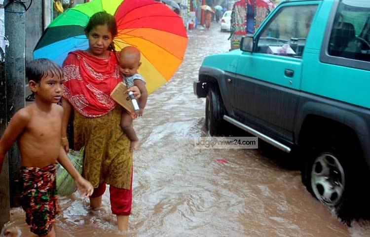 মায়ের সঙ্গে বৃষ্টিতে শিশুটি বাজার নিয়ে বাসায় ফিরছে। বৃষ্টির জলাবদ্ধতা জীবনের চাকা থামাতে পারছে না। ছবি : বিপ্লব দিক্ষিৎ