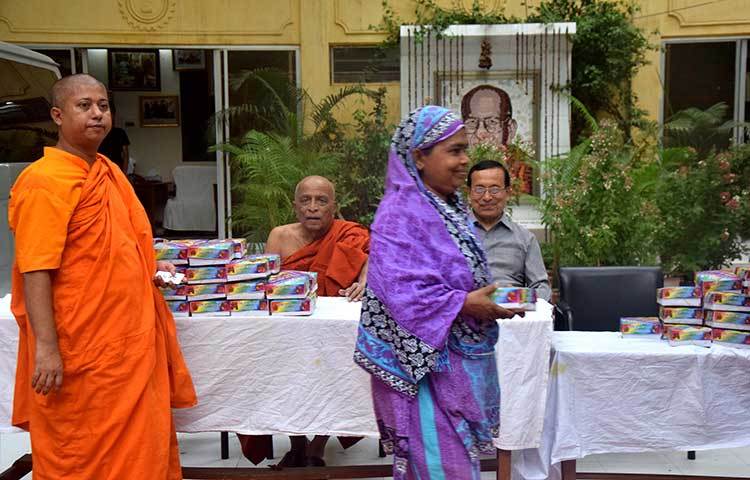 ইফতারের পসরা সাজিয়ে বিহারের প্রধান ভিক্ষু বসে গেলেন। টেবিলে থরে থরে সাজানো ইফতারের প্যাকেট। ছবি : মাহবুব আলম