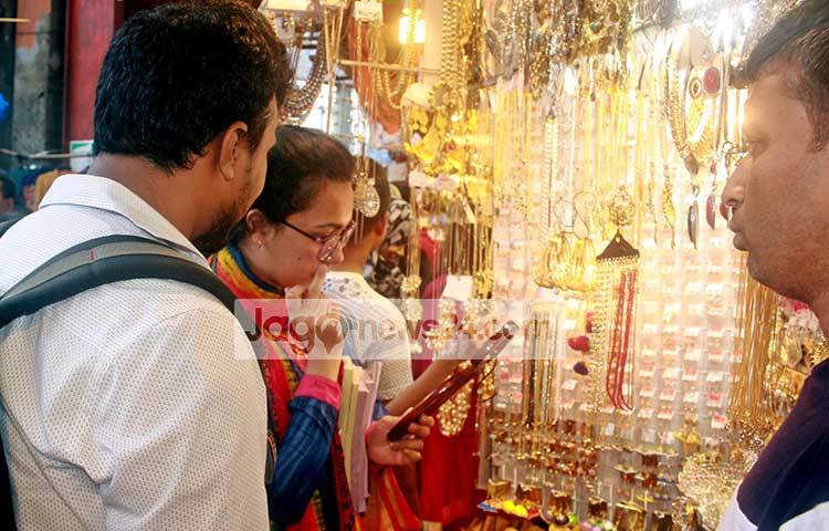 গহনা মানানসই হয়েছে কিনা তা পরে দেখছেন এই ক্রেতা। ঢাকার অন্যান্য স্থানের চেয়ে চাঁদনী চকে অনেক সুলভে গহনা কেনা যায়। তাই এখানে একটু ভিড় বেশি বলে বিক্রেতারা জানিয়েছেন। ছবি : বিপ্লব দিক্ষিৎ