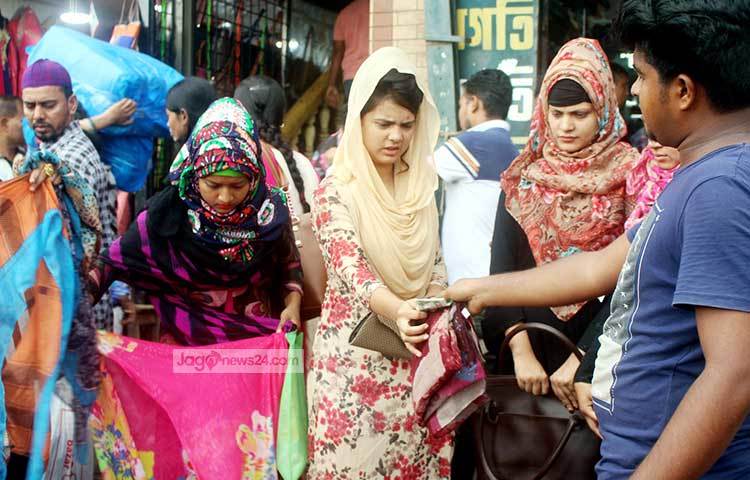 এই দোকানটিতে ক্রেতাদের উপচে পড়া ভিড়। বিক্রি ভালো হওয়াতে দোকানীরা অনেক আনন্দিত। ছবি : বিপ্লব দিক্ষিৎ