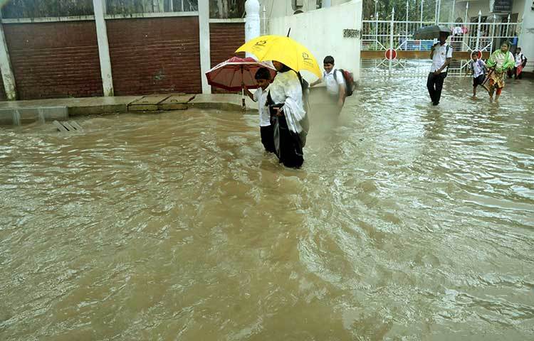 রাজারবাগ পুলিশ লাইনন্সের সামনের রাস্তা পানিতে ডুবে আছে। রাস্তা নদীর মত মনে হচ্ছে। ছবি : বিপ্লব দিক্ষিৎ