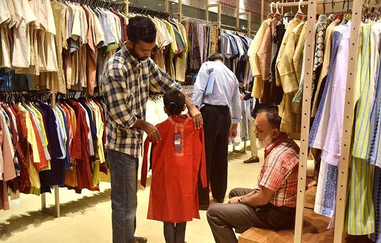 সংসারের ছোট্ট সদস্যটির জন্য ঈদের পাঞ্জাবি কিনছেন তার অভিভাবক। ছবি : মাহবুব আলম