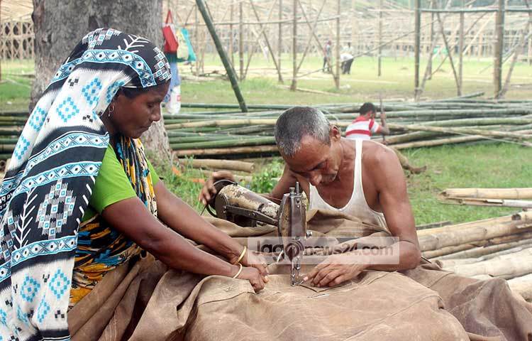 ত্রিপল সেলাইয়ের কাজ চলছে। এই ত্রিপল প্যান্ডেলের উপর বিছিয়ে দেওয়া হবে। ছবি : বিপ্লব দিক্ষিৎ&nbsp;&nbsp; &nbsp;