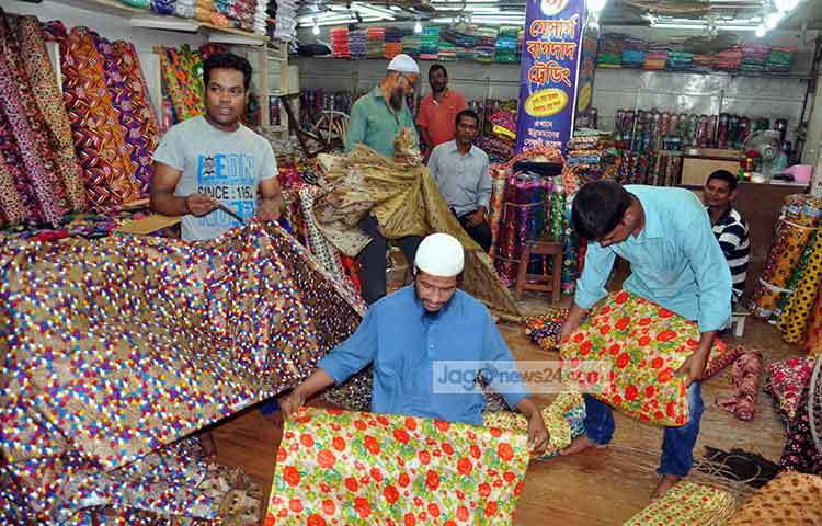 থান কাপড় বিক্রিতে ব্যস্ত বিক্রেতারা। বেচাবিক্রি ভালো হওয়ায় বিক্রেতারা অনেক খুশি। ছবি : বিপ্লব দিক্ষিৎ